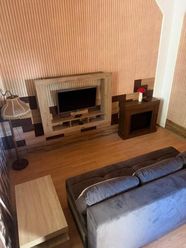 a living room with a couch and a flat screen tv at House by the Sea in Herceg-Novi