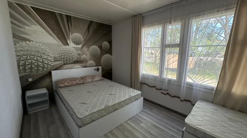 a small bedroom with a bed and a window at Voyage in Sevan
