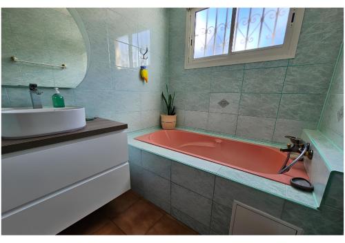 a bathroom with a red tub and a sink at Ilodays in La Plaine des Cafres