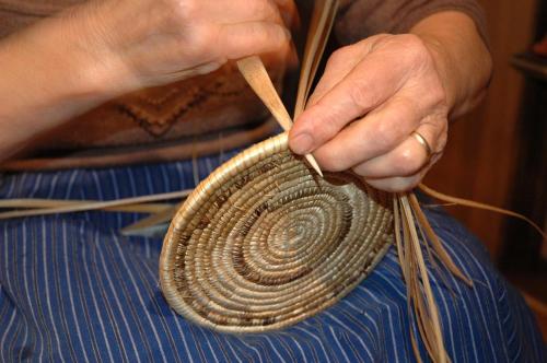 a woman is holding a coil of rope and a pair of chopsticks at Suni Rural Relax in Suni