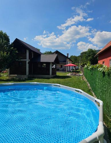 a large blue swimming pool in front of a house at Vikendica Stanković in Šipovo