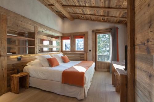 a bedroom with a bed and a television in it at Au Coin Du Feu in Megève