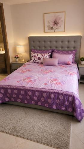 a bedroom with a purple bed with a purple comforter at Résidence Haute Standing Corniche in Martil