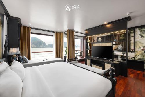 a bedroom with a white bed and a large window at Aqua of the Seas Cruise in Ha Long