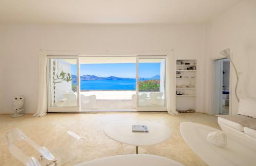 a white living room with a view of the ocean at Sunset Flower Villa in Kástron