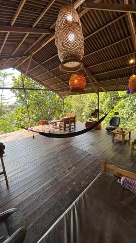 a room with a hammock on a wooden deck at Hostal CASA COLIBRI MINCA in Minca