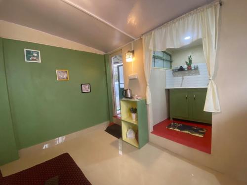 an empty room with green walls and a window at GD's Homestay in Shillong