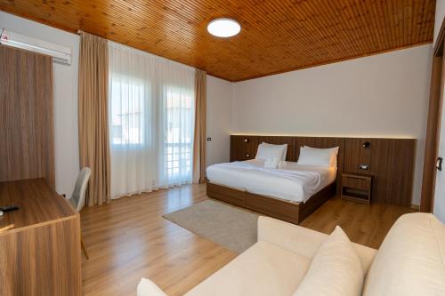 a bedroom with a bed and a couch in it at Hotel Aleks in Shkodër