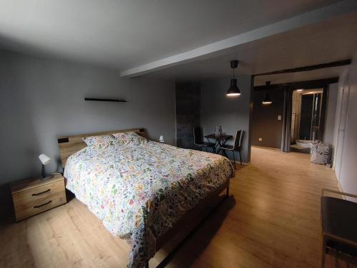a bedroom with a bed and a table with chairs at Le petit Broux in Aywaille