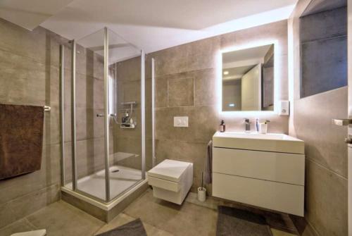 ein Badezimmer mit Dusche, Toilette und Waschbecken in der Unterkunft Teddis Traubing in Tutzing