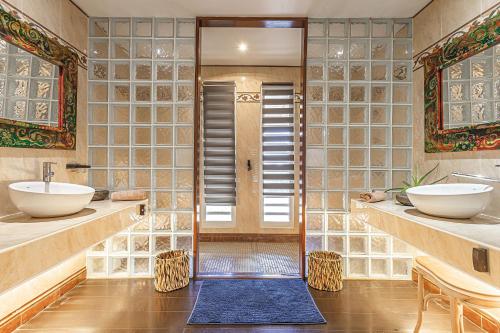 a bathroom with two sinks and a walk in shower at Villas ti creole nogent in Sainte-Rose