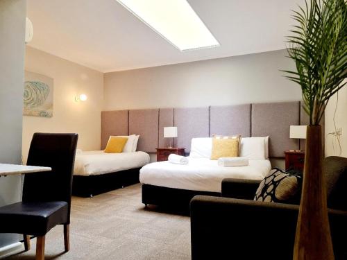 a hotel room with two beds and a couch at Bay & Basin in Sanctuary Point
