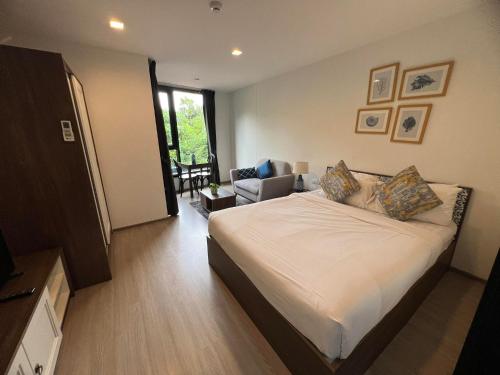 a bedroom with a bed and a chair in it at The Base Central Phuket-B2-Y9B in Ban Rangeng