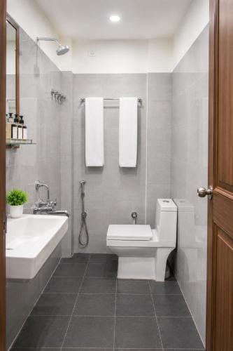 a bathroom with a sink and a toilet and a tub at Hotel MountView Comforts in Tirupati