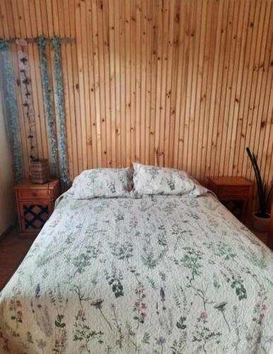 a bedroom with a bed with a floral bedspread at Loft vista a la bahía in Valparaíso