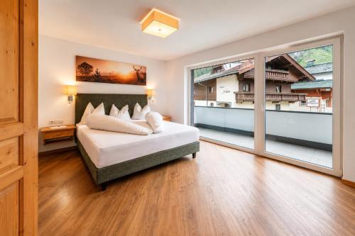 a bedroom with a bed and a large window at Chalet Perauer in Mayrhofen