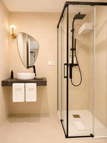 a bathroom with a shower with a sink and a mirror at Zarú Hotel Boutique in Mocejón