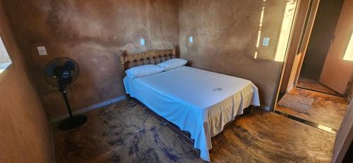 a small bedroom with a bed with a blue blanket at Recanto do Baru in Pirenópolis