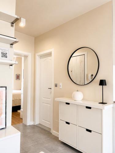 a bathroom with a mirror and a white dresser at Luxury Central Apartment in Plovdiv