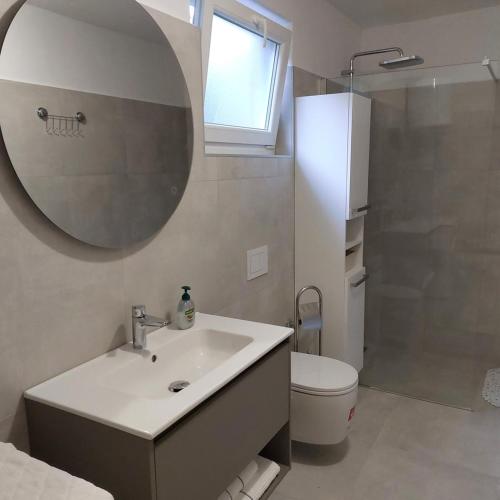 a bathroom with a sink and a mirror and a toilet at Apartment Mare - Beachfront in Rabac