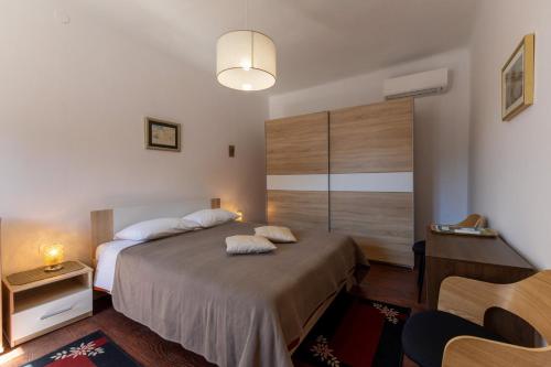 a bedroom with a bed with two pillows on it at Apartment Mare - Beachfront in Rabac