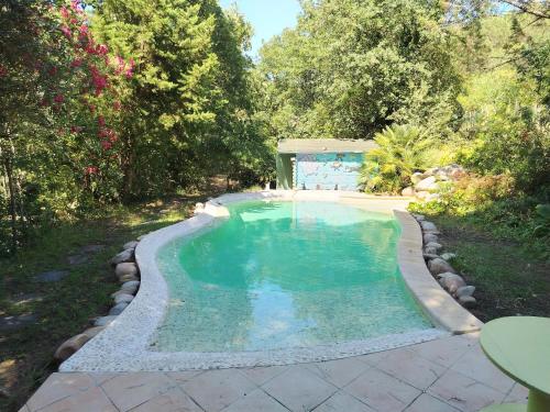 a swimming pool in a yard with rocks around it at Roulotte Fenouillet in Hyères