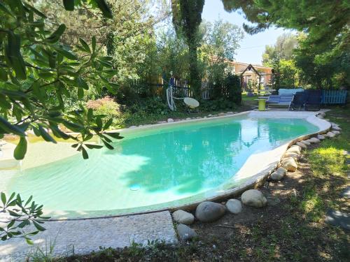 a swimming pool in a yard with rocks around it at Roulotte Fenouillet in Hyères
