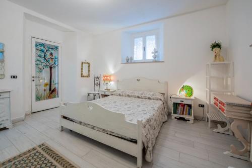 a white bedroom with a bed and a piano at Casa dei Pavoni in Monte Gallo
