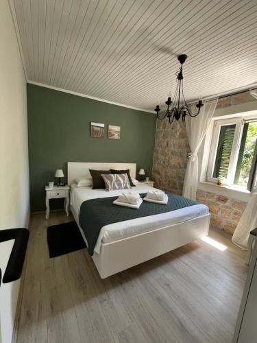 a bedroom with a bed and a chandelier at Charming apartment piccolo paradiso in Vlašići