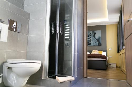 a bathroom with a toilet and a glass shower at VillaJazz Apartments in Murau
