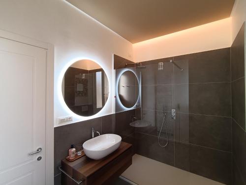 a bathroom with a sink and a shower with a mirror at Lodge 46 Luxury Apartment in Marghera