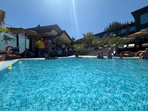 a large blue swimming pool with people in it at Мия 2 Deluxe Royal Spa in Velingrad