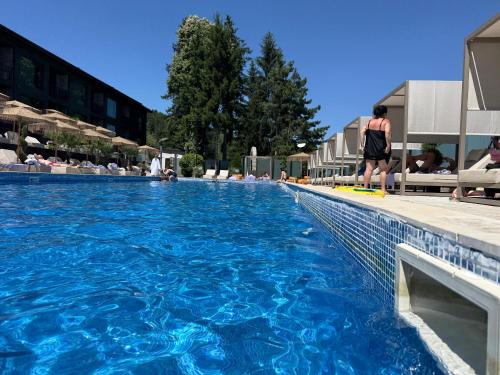 a person standing next to a swimming pool at Мия 2 Deluxe Royal Spa in Velingrad