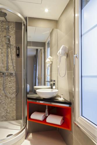 une salle de bain avec un lavabo et une douche dans l'établissement Timhotel Paris Gare de l'Est, à Paris