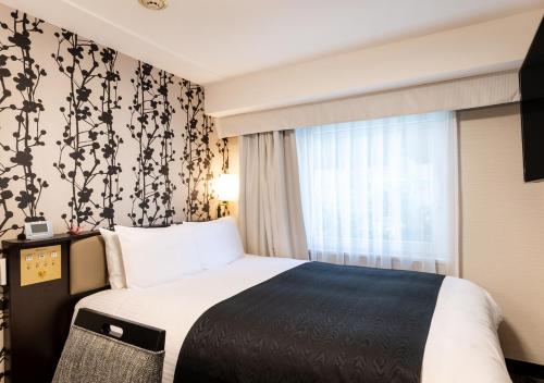 a hotel room with a bed and a window at APA Hotel Kyoto Eki Horikawadori in Kyoto
