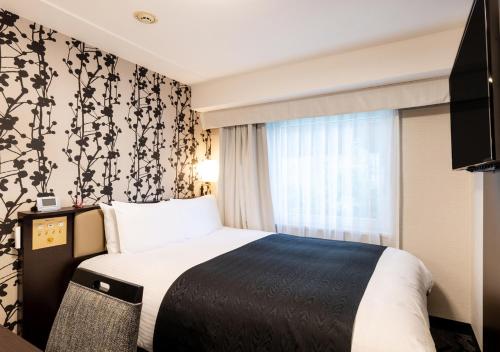 a hotel room with a bed and a window at APA Hotel Kyoto Eki Horikawadori in Kyoto