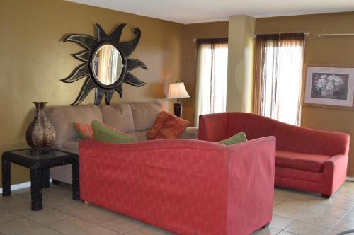 a living room with two red couches and a mirror at The Summit Condominiums in Panama City Beach