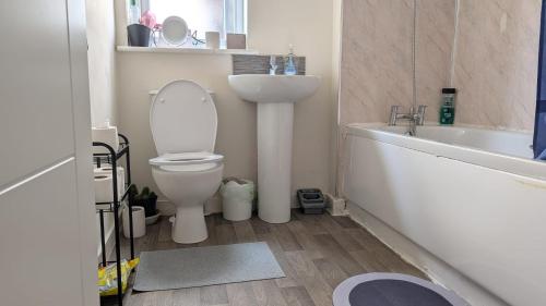 a bathroom with a toilet and a sink and a tub at NG Property in Glasgow