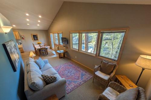 a living room with a couch and chairs and windows at River Pines Inn in Winthrop