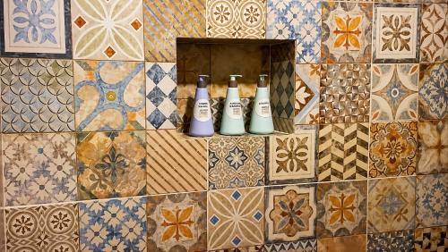 a group of bottles on a tiled wall at Raíces in Puerto Pirámides