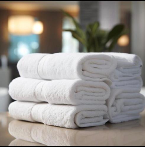 four towels stacked on top of each other on a table at Luxury Room In McDonough in McDonough