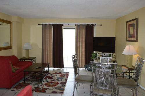 a living room with a red couch and a glass table at The Summit Condominiums in Panama City Beach