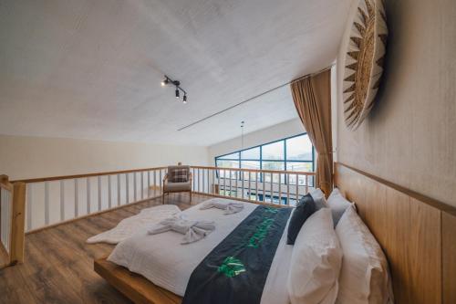 a bedroom with a bed and a balcony at Nish Vadi Villas in Sapanca