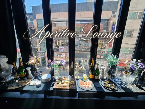 a table with food and bottles of wine in a window at Friendly DH Naissance Hotel by Mindrum Group in Seoul