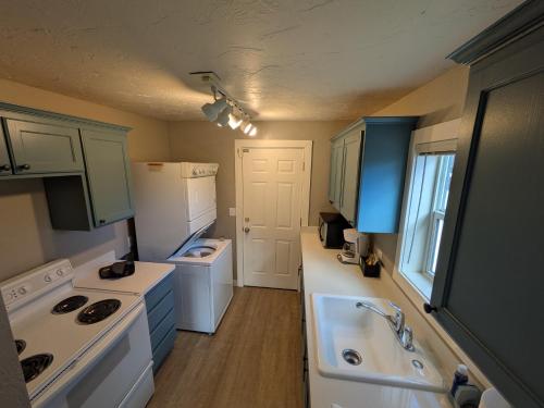 a small kitchen with white appliances and a sink at River Pines Inn in Winthrop