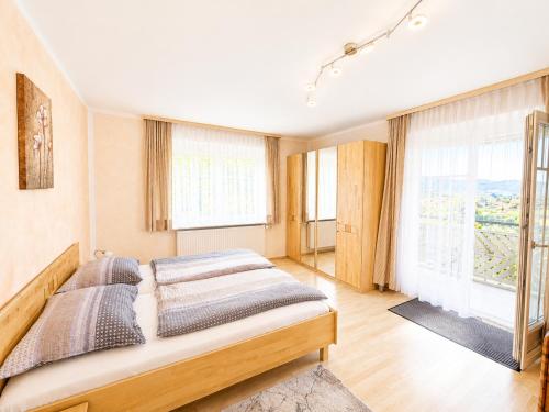 a bedroom with a bed and a large window at Feistritzer in Seeboden