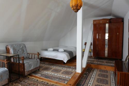a bedroom with a bed and a chair in a room at SpaOk & Play in Mărgăriţi
