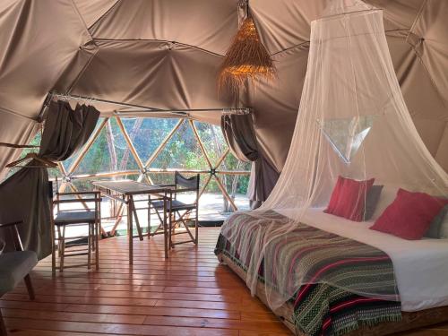 a bedroom with a bed in a tent with a table at Salema Eco Camp - Sustainable Camping & Glamping in Salema