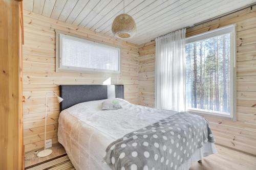 a bedroom with a bed in a wooden room at Villa Winter - Valkea Homes in Pyhätunturi