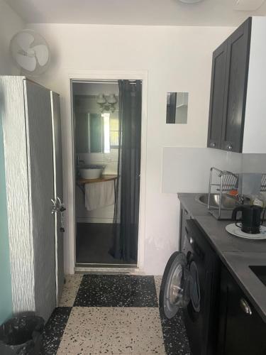 a kitchen with a door open to a bathroom at Appartement Mimosa, climatisation, tram 2, parking in Montpellier